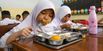 PELAKSANAAN PROGRAM MAKAN BERGIZI GRATIS:  Siswa menyantap hidangan makan bergizi gratis di SD Barunawati, Palmerah, Jakarta Barat, Senin (6/1/2025). Program makan bergizi gratis tersebut diharapkan bisa menyentuh tiga juta penerima manfaat, yang terdiri dari balita, santri, siswa PAUD, TK, SD, SMP, SMA, dan ibu hamil serta ibu menyusui. MI/Usman Iskandar